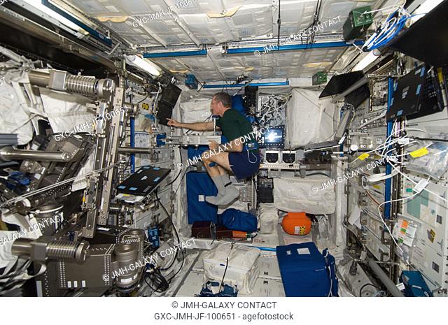NASA astronaut Dan Burbank, Expedition 30 commander, uses the Space Linear Acceleration Mass Measurement Device (SLAMMD) in the Columbus laboratory of the...