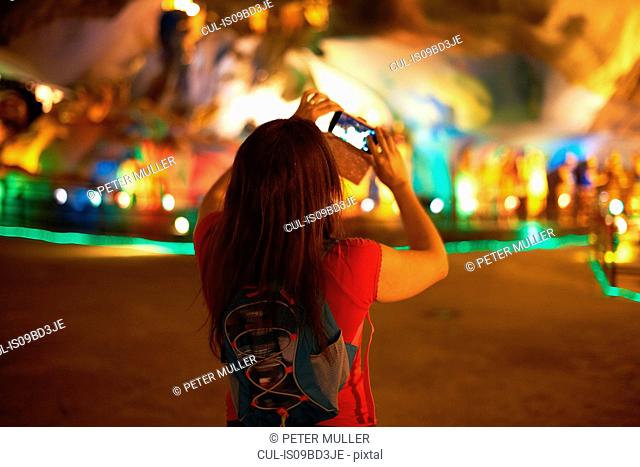 Tourist taking photograph of light decorations, Batu Caves, Kuala Lumpur, Malaysia