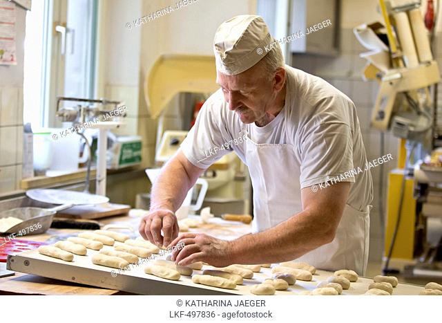 Baker Erwin Oehl making breadrolls in his bakery, Frankenau, Hesse, Germany, Europe