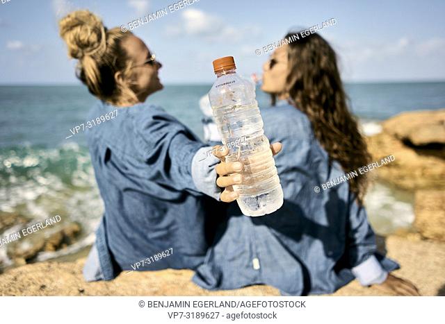 Two women sitting at beach, Chersonissos, Crete, Greece