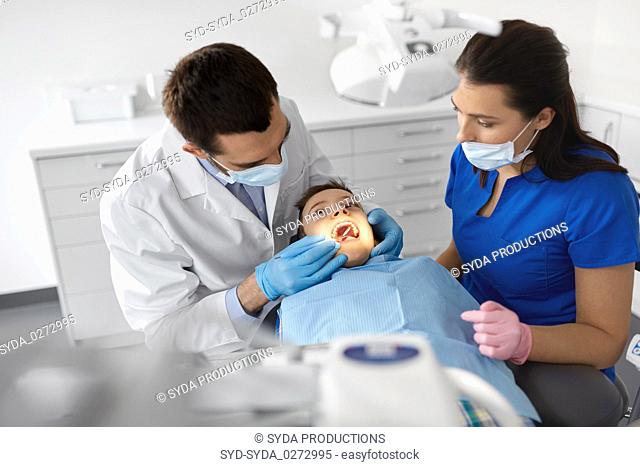 dentist checking for kid teeth at dental clinic