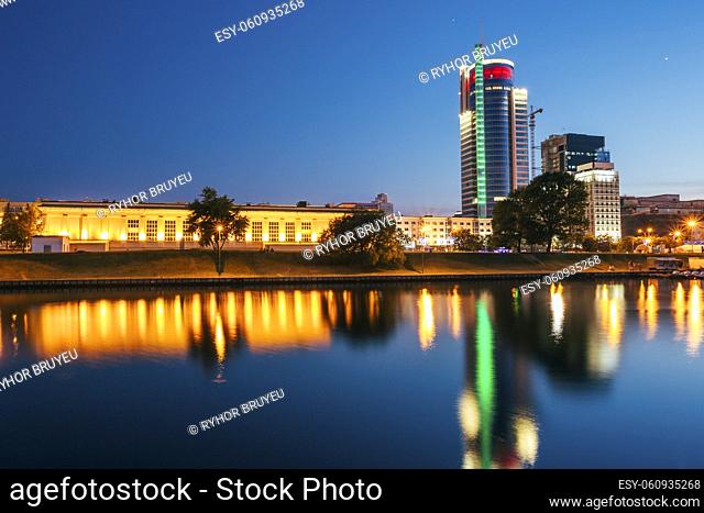 Sunset over central district Nemiga in Minsk, Belarus. Reflection of night street lights in rivers water