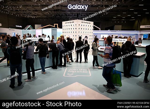 01 September 2023, Berlin: Visitors stand by the Samsung booth at the foldable smartphones as well as smartwatches and tablets during the International Consumer...