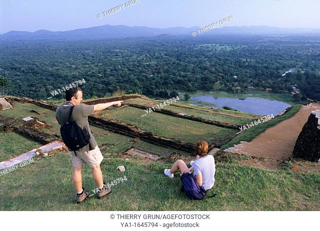 Couple tourist looking panorama on summit of old royal palace vestiges, Sigiriya Lion's rock fortress, Sri Lanka