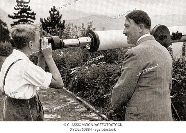 Adolf Hitler at his residence in Obersalzberg, Bavaria, Germany in 1936, watching a boy observing the Unterberg Mountain through a telescope