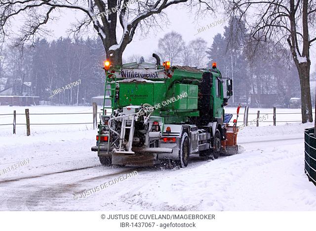 Snow-clearing vehicle clearing the road from snow and ice, spreading sand against black ice, Norderstedt, Schleswig-Holstein, Germany, Europe
