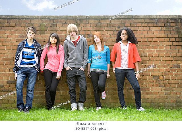 Teens standing by wall