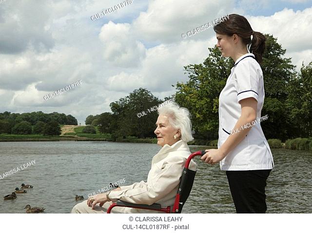 Elderly woman in wheelchair with nurse
