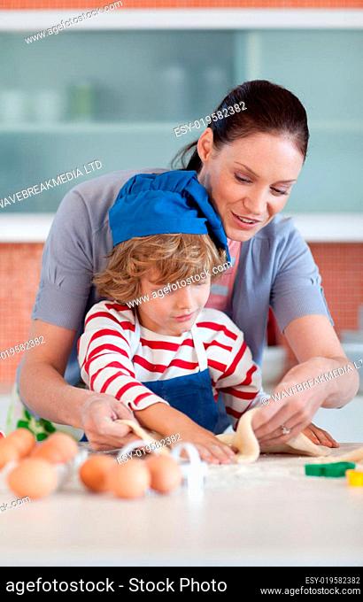 Radiant mother and her son baking at home
