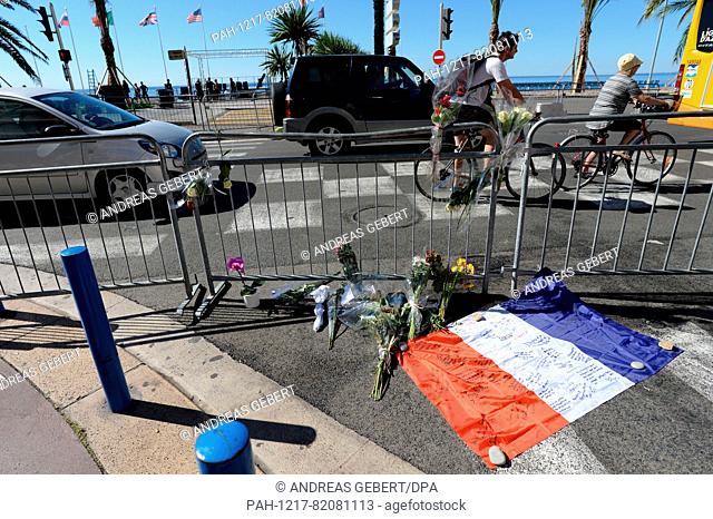 A French flag lies in front of a fence at the scene, where a truck drove into a crowd during Bastille Day celebrations on 14 July 2016, in Nice, France, July 16