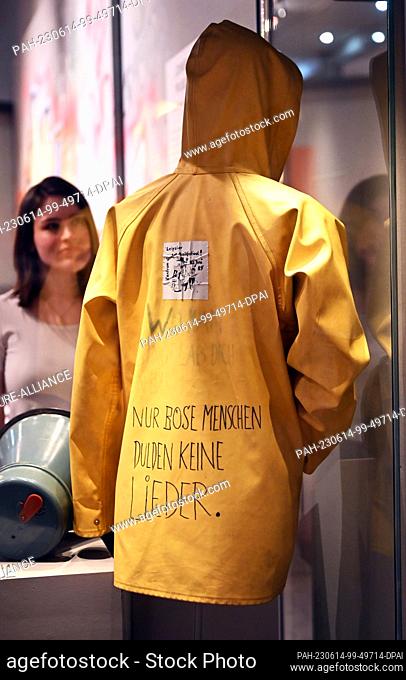 PRODUCTION - 12 June 2023, Baden-Württemberg, Karlsruhe: ""Only bad people don't tolerate songs"" is written on a yellow oil jacket from the 1980s that is part...