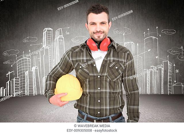 Composite image of handyman with earmuffs holding helmet