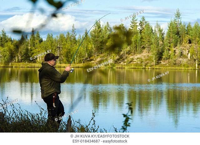 Fisherman on the little lake, beautiful landscape on background
