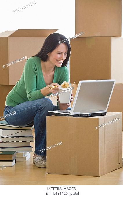 Woman eating take out food in new house