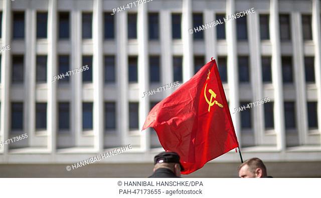 Men hold a Soviet era red flag in front of the parliament building after the end of the referendum in Simferopol in Simferopol, Crimea, Ukraine, 17 March 2014