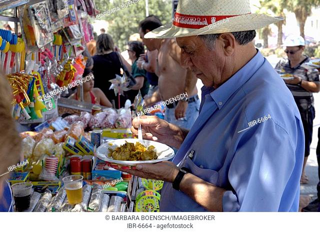 Man eats paella at the Fiesta St. Joan, Altea, Costa Blanca, Spain