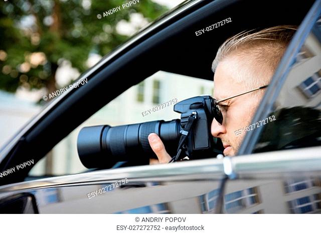Paparazzi Sitting Inside Car Photographing With SLR Camera