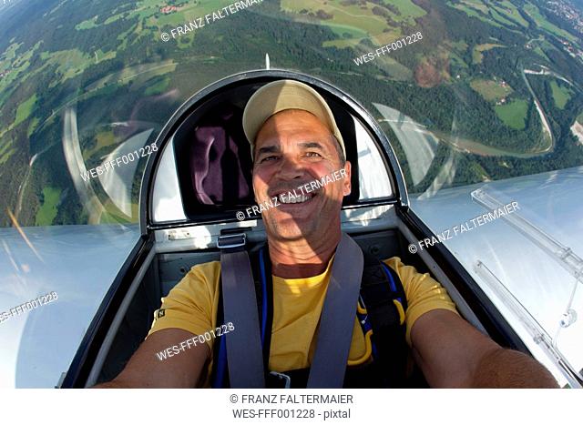 Germany, Bavaria, Bad Toelz, Mature man in glider, smiling, portrait