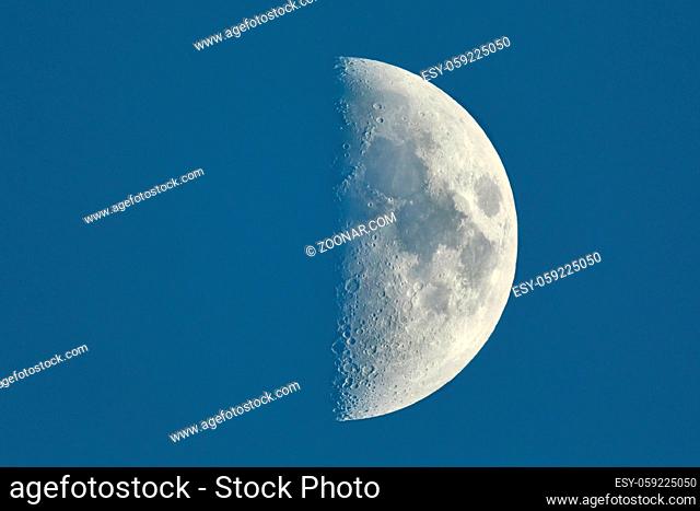 The moon showing against blue sky, detailed shot taken at 1600mm focal length