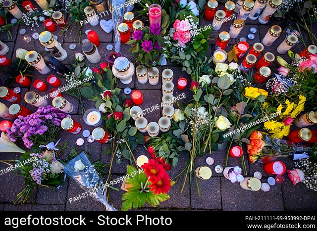 11 November 2021, Saxony-Anhalt, Aschersleben: A ""J"" made of candles stands on the Holzmarkt in the midst of countless flowers and candles