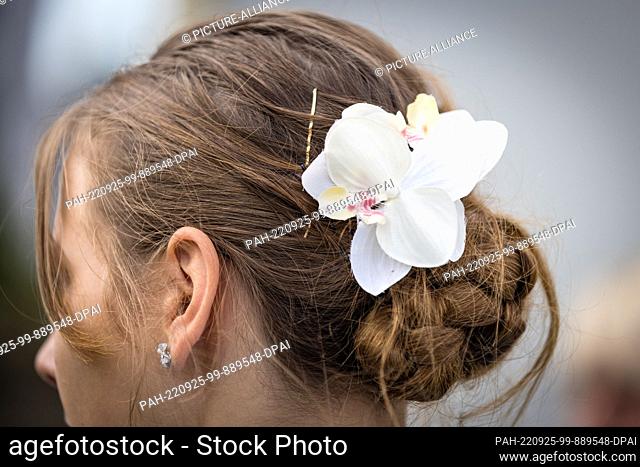 24 September 2022, Brandenburg, Neu Zauche: A participant of the SuperKokot event wears a flower in her hair. In the traditional SuperKokot - super cock...