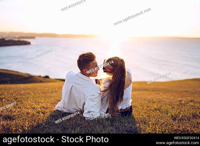 Romantic couple relaxing on hill at Mirador de La Providencia, Gijon, Spain