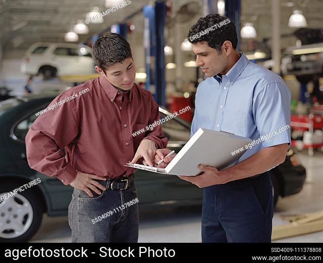 Car salesman and customer signing a contract