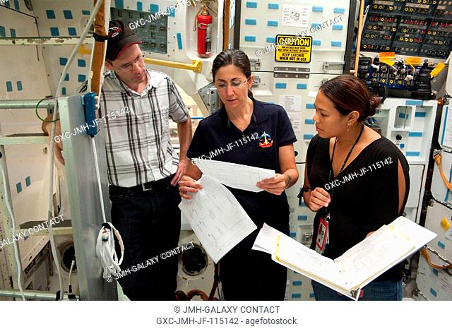 NASA astronaut Nicole Stott (center), STS-133 mission specialist, participates in a training session in an International Space Station mock-uptrainer in the...