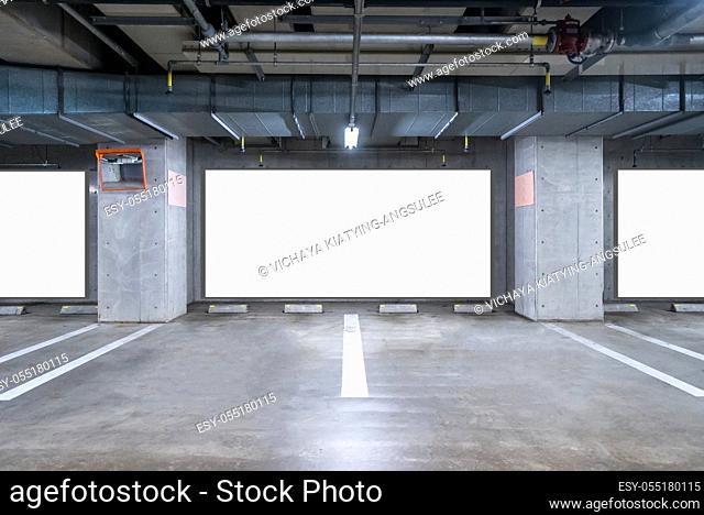 empty Parking garage underground with blank billboard, interior shopping mall at night