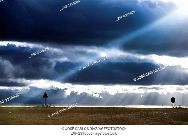 A ray of light breaks through the clouds and falls on a road, Segovia, Spain