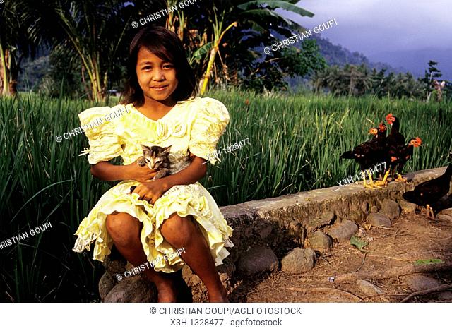 young girl in yellow dress with a cat, Sumatra island, Republic of Indonesia, Southeast Asia and Oceania