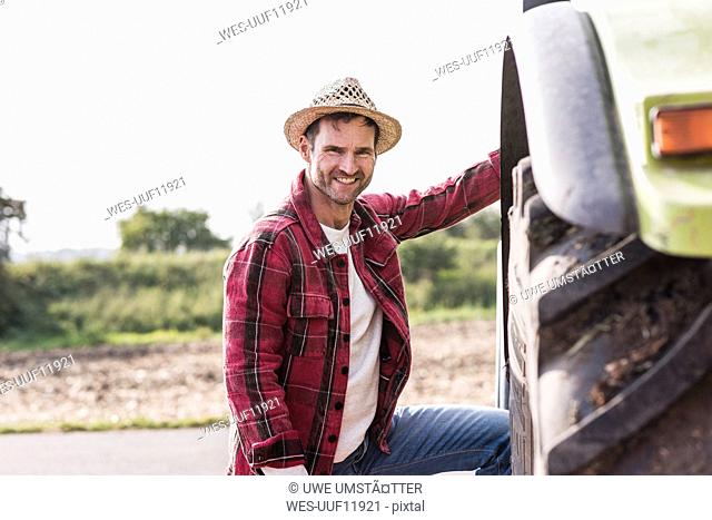 Portrait of confident farmer with tractor