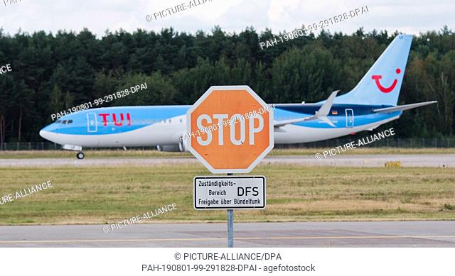 31 July 2019, Lower Saxony, Hanover: A Boeing 737-800 from Tuifly passes a stop sign of DFS Deutsche Flugsicherung at Hannover Airport at take-off