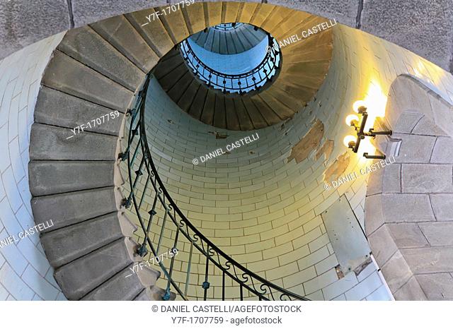 Angle shot of a lighthouse's spiral stair lighted by electric lamp, vortex