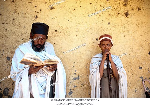 Orthodox christian man and woman during a mass. The man is reading the bible written in Ge'ez a forerunner of modern Amharic language