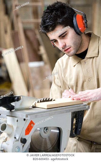 Carpenter cutting wood with electrical saw. Wood carpentry
