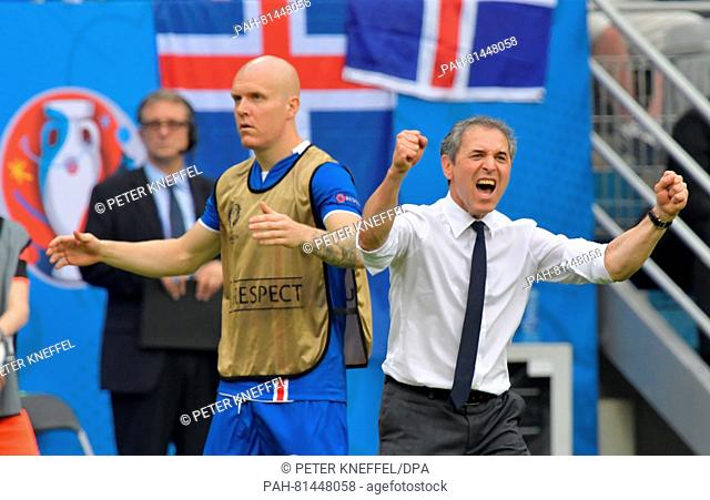 Austria's coach Marcel Koller (R) celebrates the 1-1 equalizer as Iceland's Emil Hallfredsson looks on during the Group F preliminary round soccer match of the...