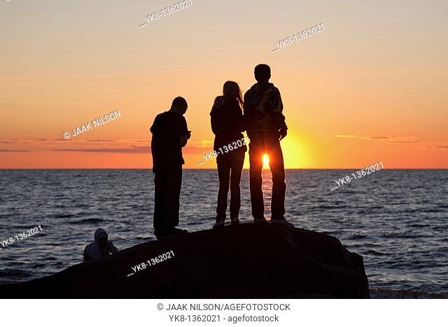 People Silhouettes at Sunset on Beach