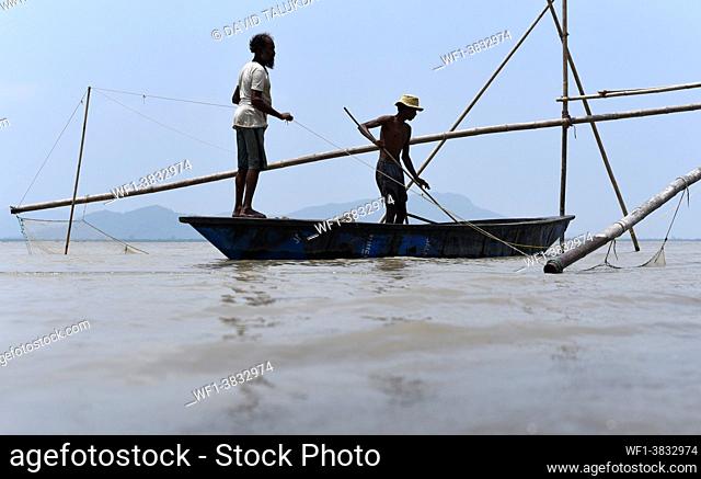 Fishermen lay fishing net in the in the Brahmaputra river, in Guwahati