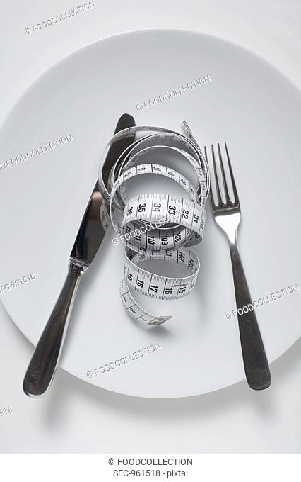 Knife and fork and tape measure on plate