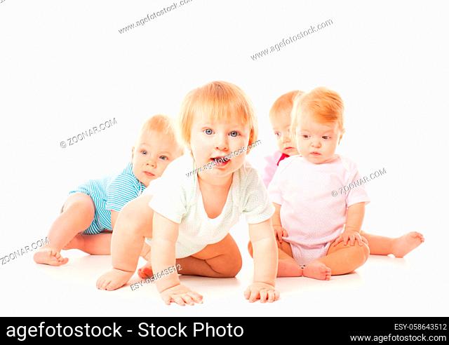 Group of funny babies sitting in different clothes, isolated on white background