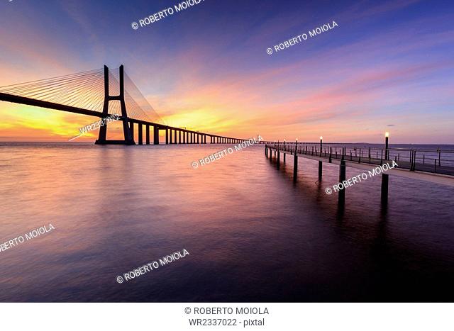 The colors of dawn on Vasco da Gama Bridge that spans the Tagus River, Lisbon, Portugal, Europe