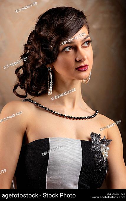 Retro woman portrait. Beautiful lady in 20s or 30s style. Old fashionable Finger Wave makeup and hairstyle