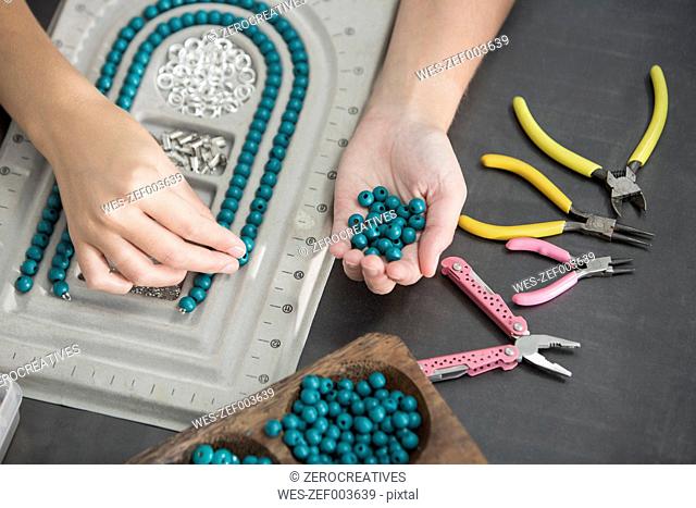 Close-up of woman working with beads to create a necklace
