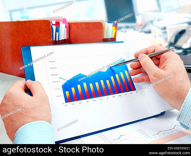 Male hand with pen on the investment chart
