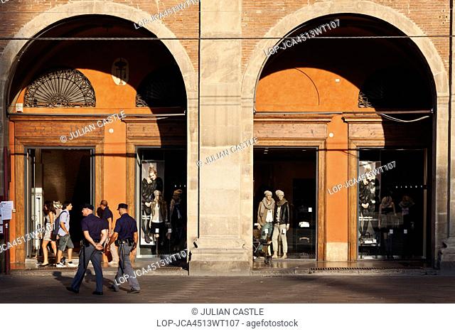 Italy, Emilia-Romagna, Bologna. Carabinieri police passing shopping arcades in Piazza Maggiore in Bologna