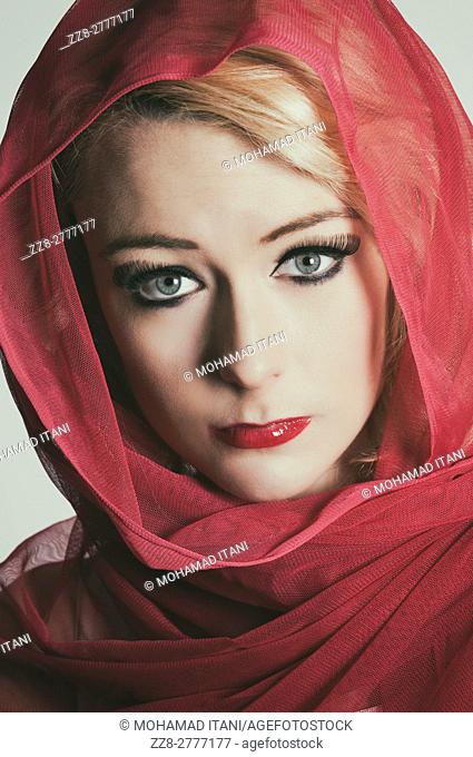 Beautiful woman wearing a red headscarf looking scared