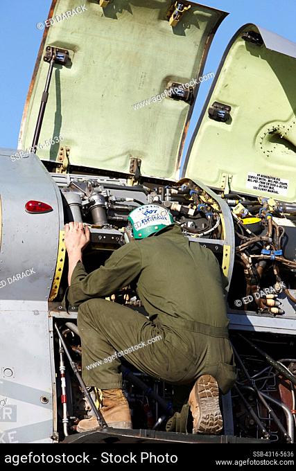 United States Marine Corps aircraft maintenance specialist working on an engine housed inside an engine nacelle of an MV-22 Osprey, Camp Bastion