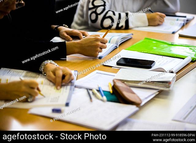 09 November 2023, Berlin: Participants sit hunched over textbooks in a German course at a Berlin language school. Photo: Christoph Soeder/dpa