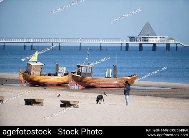 12 April 2020, Mecklenburg-Western Pomerania, Ahlbeck: Fishing boats stand in the morning light on the Baltic Sea beach of Albeck on the island of Usedom